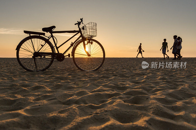 日落时分在海滩上骑自行车