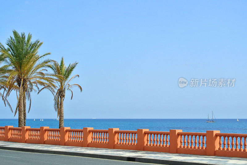 西班牙安达卢西亚马拉加省，从贝纳尔马德纳海滩的海滨步道和前方长满棕榈树的道路上眺望地中海。