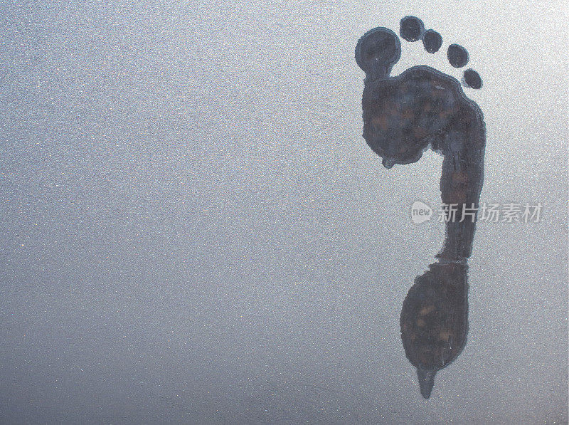 一只赤脚踩在冰冻玻璃上的痕迹