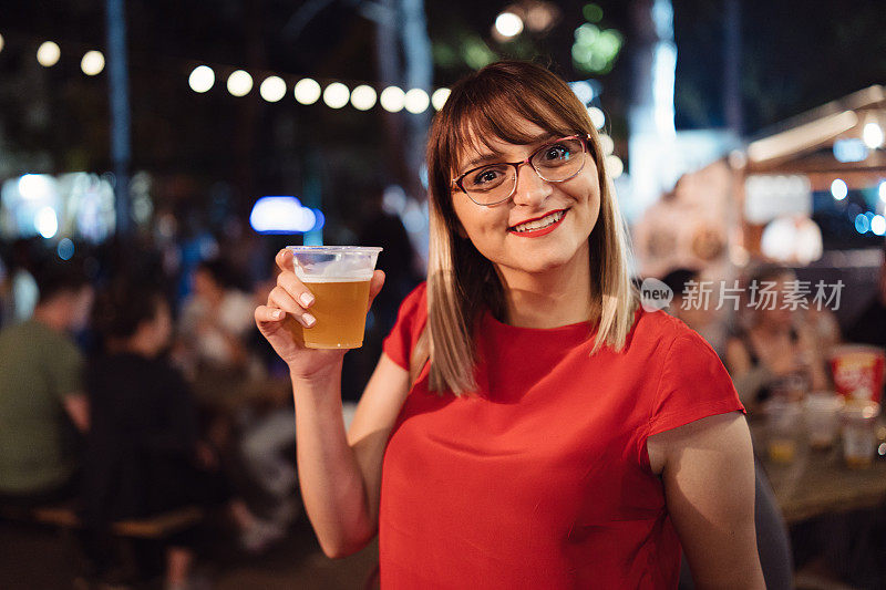 在夏季节日上喝啤酒的女人