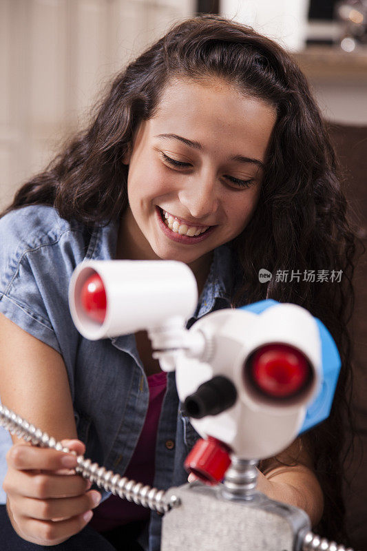 十几岁的女孩在家学习科学和工程。家庭作业。