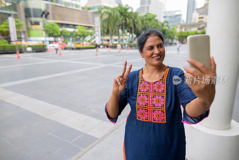 成熟美丽的印度女人的肖像放松在泰国曼谷暹罗广场购物中心