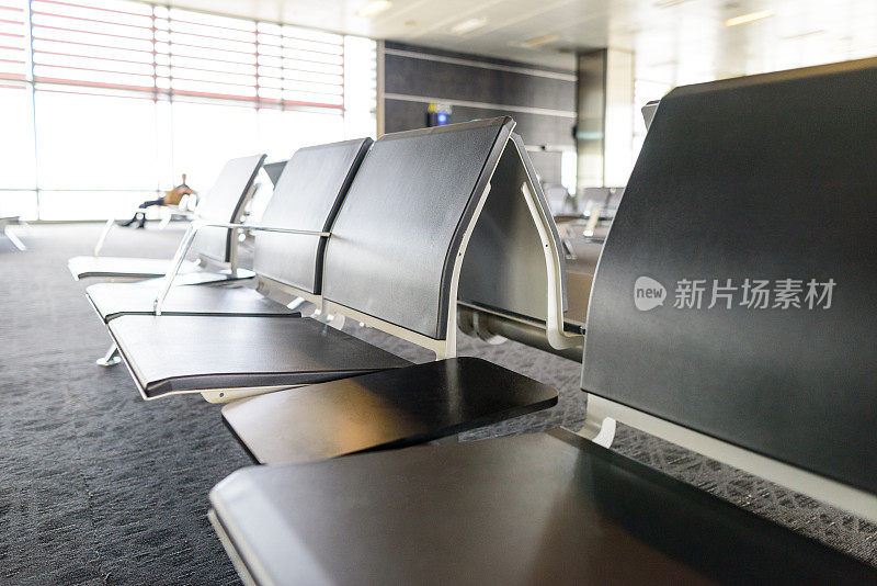 机场候机厅的空椅子，火车站窗边一个旅客模糊的剪影。旅行和交通概念