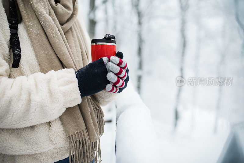 女人双手握着一杯热可可，茶或咖啡。冬季和圣诞节的时间概念。