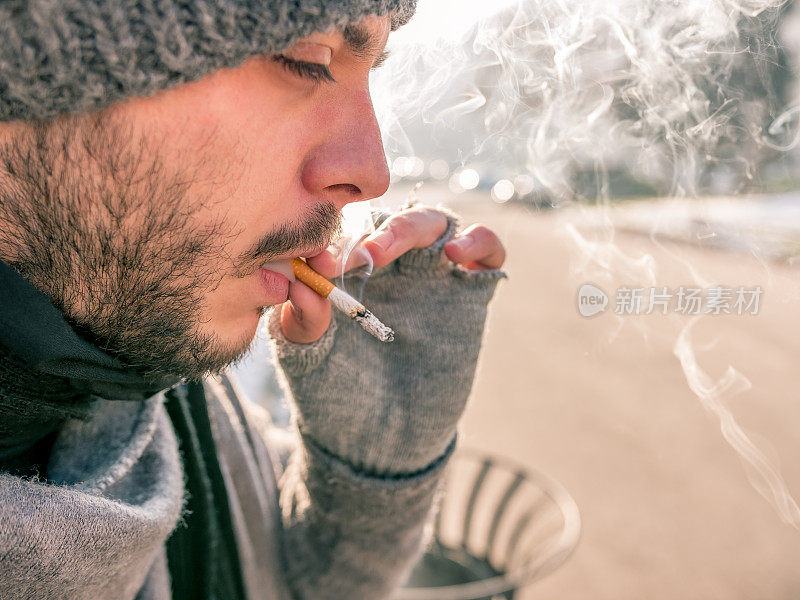 一个男人在户外吸着烟的特写镜头