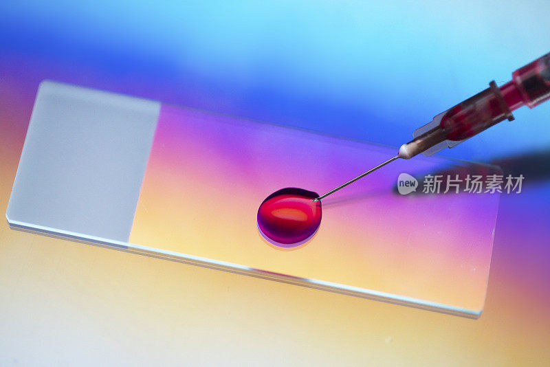 显微镜载玻片与血样注射器在微光下