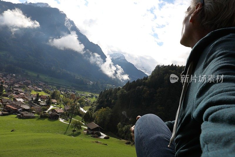 人们越过草地和村庄，望向群山