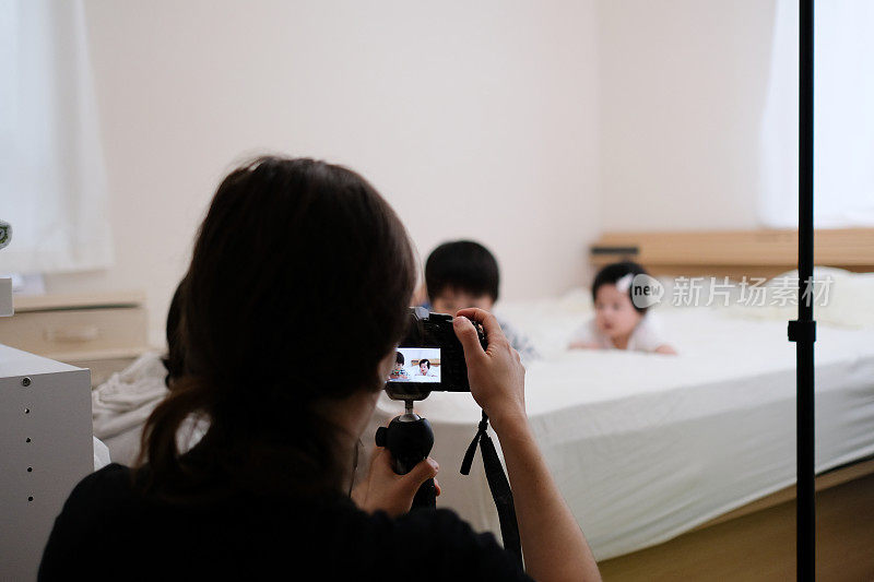 摄影师在床上给孩子拍照
