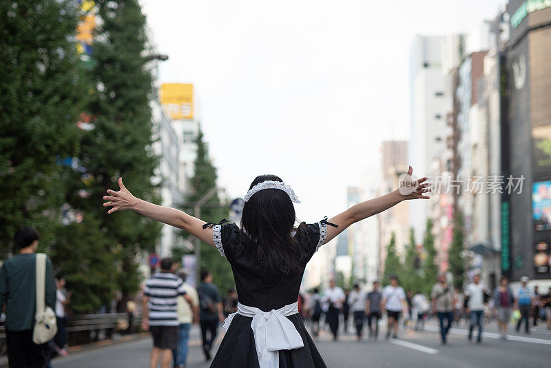 在东京秋叶原街头，Cosplay女仆张开双臂放松