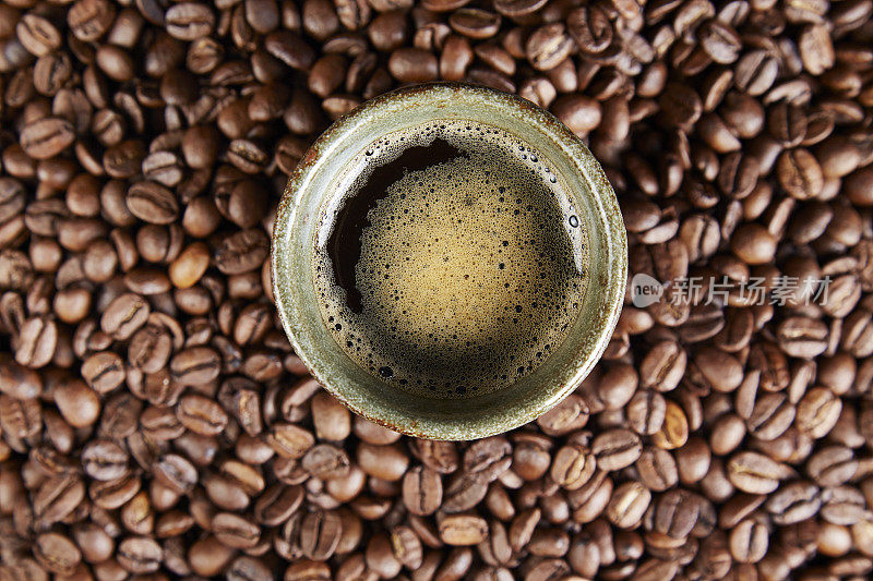 黑色背景上的咖啡杯和咖啡豆