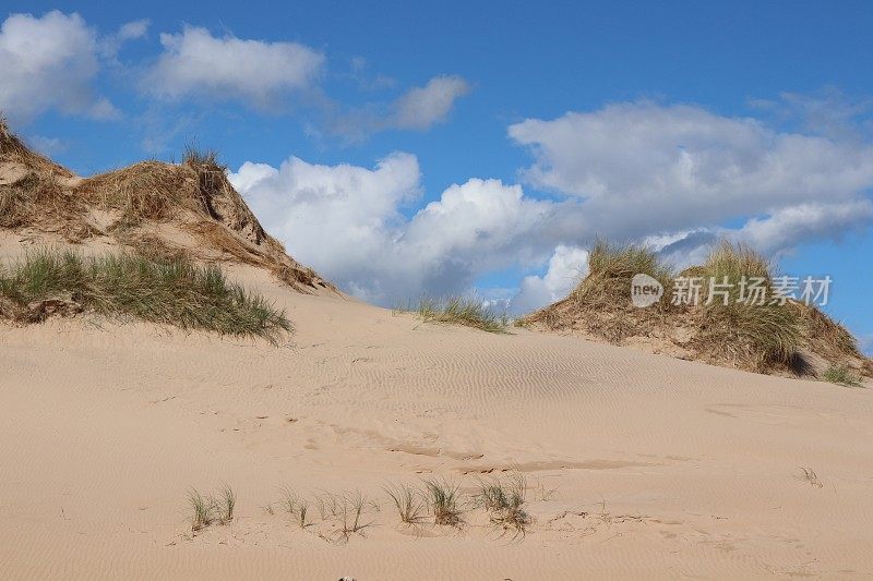 沙丘和大海上蓬松的白云