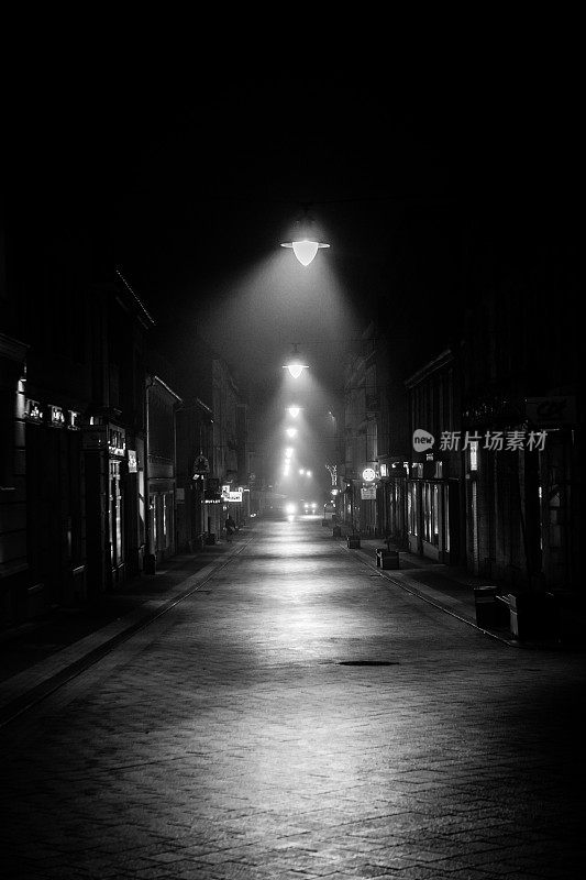 黑暗的城市小巷被街灯照亮