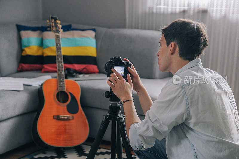 年轻的视频博主，吉他手拍摄他的视频博主