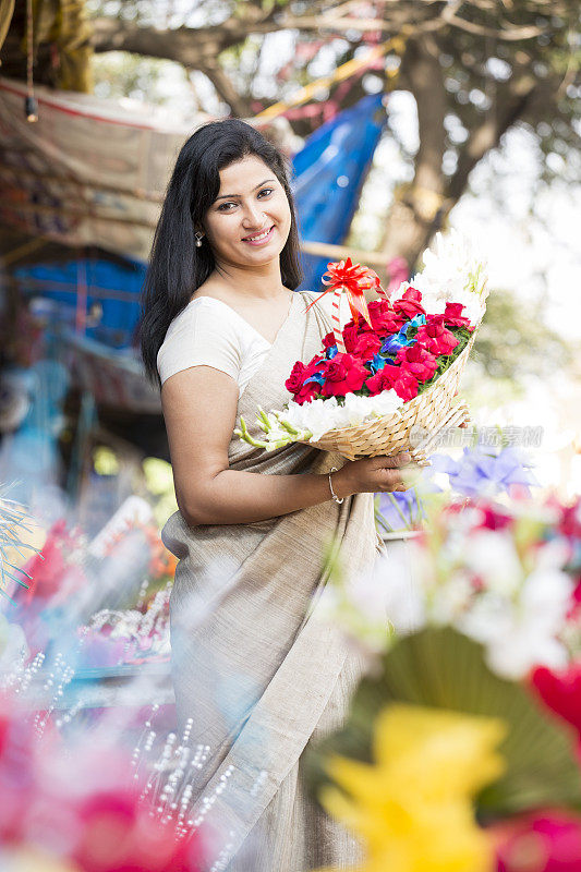 年轻女子在市场上买花