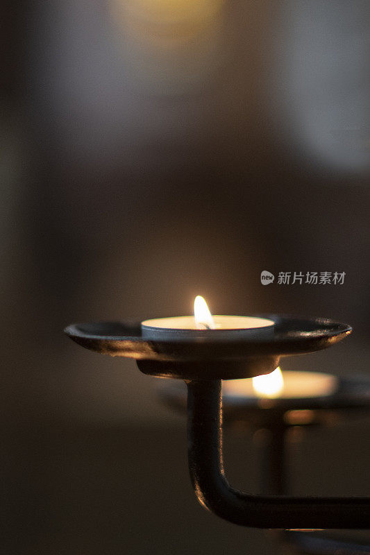 近距离的祈祷蜡烛在教堂的一排