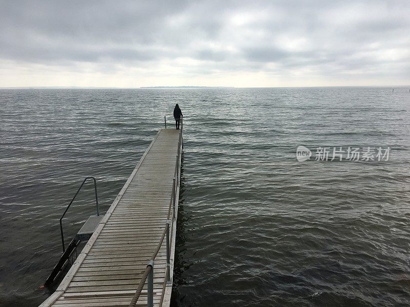 站在码头上望着大海的人