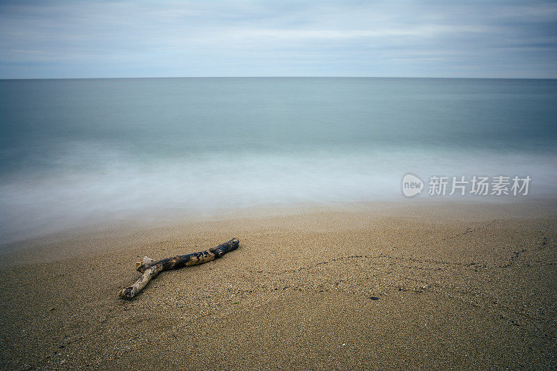 荒岛上美丽的海景，地平线上阴郁的天空，海水和海滩上的波浪。