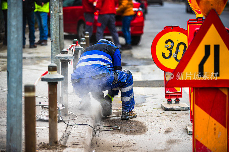 2019年，在罗马尼亚首都布加勒斯特，建筑工人使用切割锯切割人行道上的沥青路面