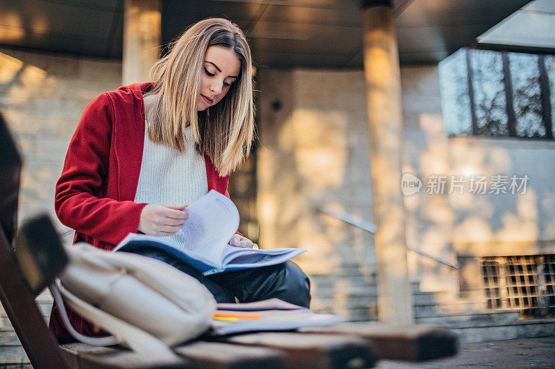 女学生坐在长凳上学习