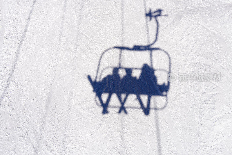 缆车上的滑雪者在雪地上的影子