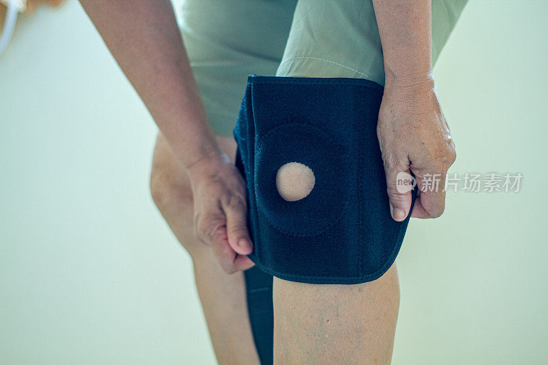 老年亚洲妇女膝盖受伤时，用膝盖支撑支架支撑腿