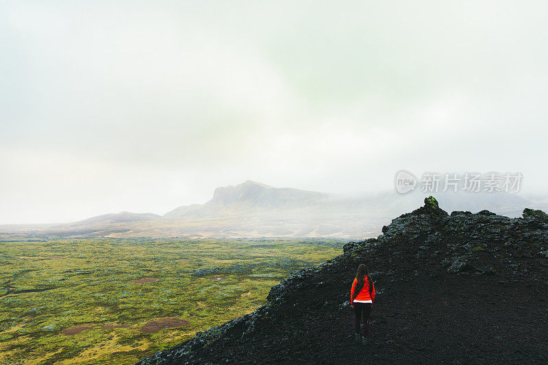 女游客在冰岛山顶欣赏风景优美的火山景观