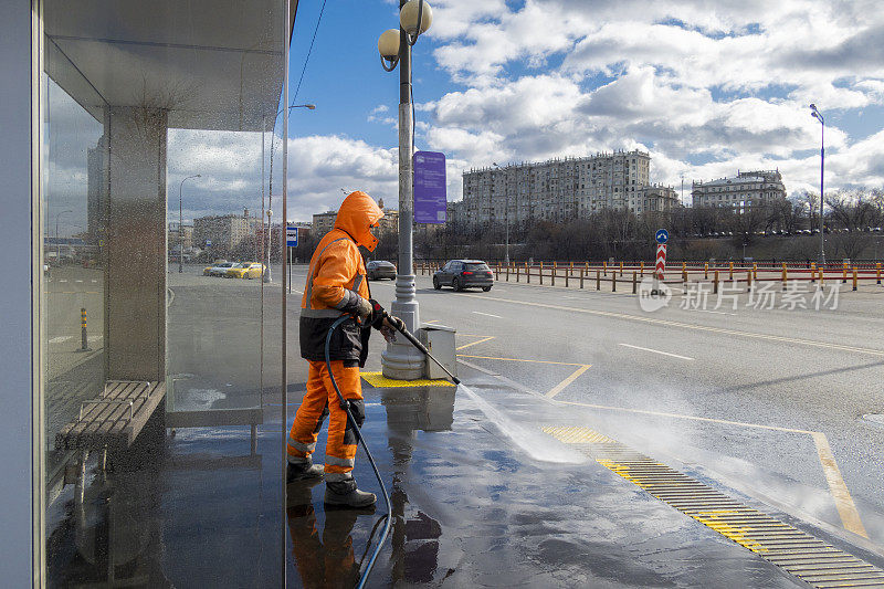 道路工人正在用电动清洗机清洁城市街道