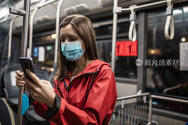 在公交车上戴着口罩的年轻女子