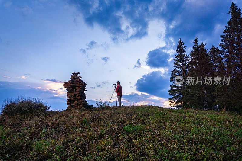 摄影师在山脊上捕捉戏剧性的日落景观