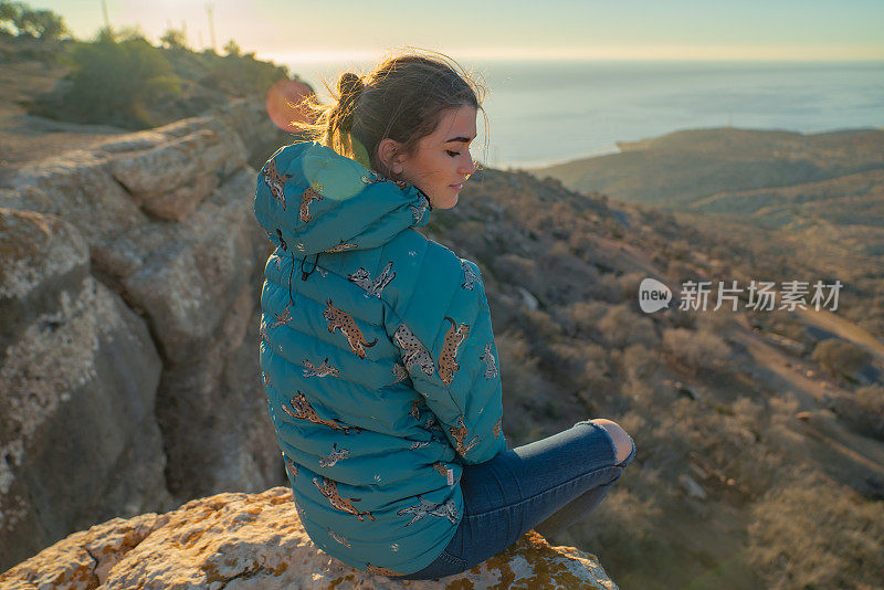 海景和山脉。从悬崖上欣赏史诗般的景色的女人