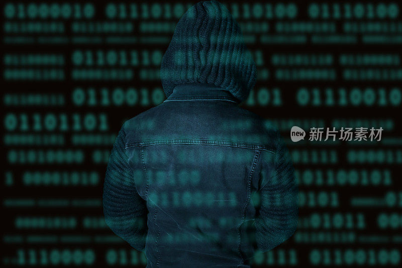 图像模糊的秘密电脑黑客程序员青年身穿帽衫与黑暗编程计算机代码背景，互联网犯罪概念