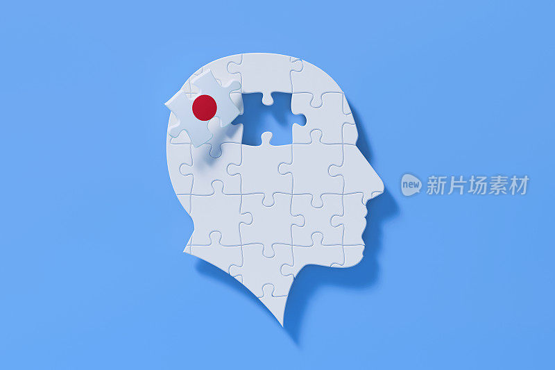 日语学习概念-在蓝色背景上形成一个人的头部形状的白色拼图