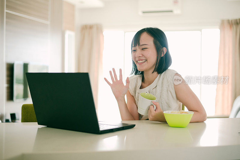 美丽的亚洲女人喜欢在家里的数字平板电脑上视频聊天。