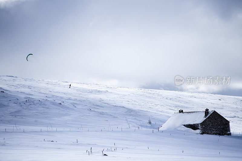 Meyzinc高原上的一座石头农舍上方的一只雪风筝