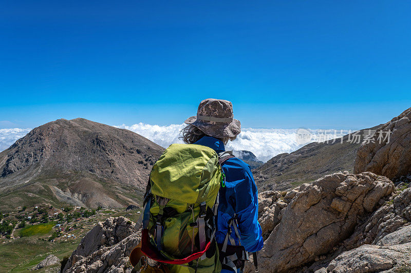 装备齐全的登山老人从山顶俯瞰，高海拔