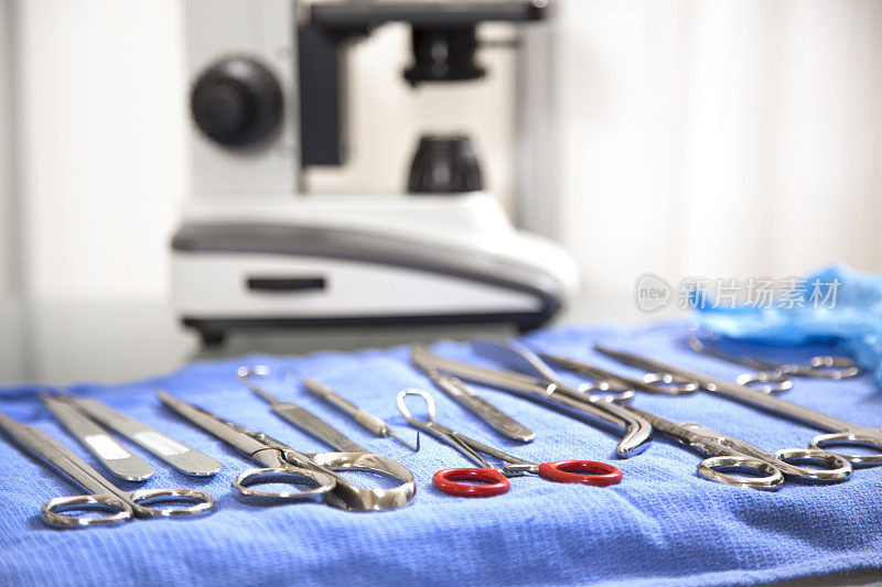 医疗-解剖或手术工具。背景显微镜，前景手术工具。