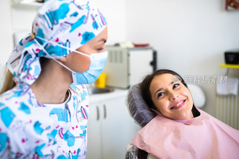 一个快乐的病人对着她的牙医微笑