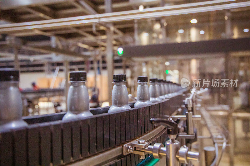 工业，商业，工厂，装瓶厂-瓶子装满了新鲜的饮料移动在传送带到工厂的包装部分
