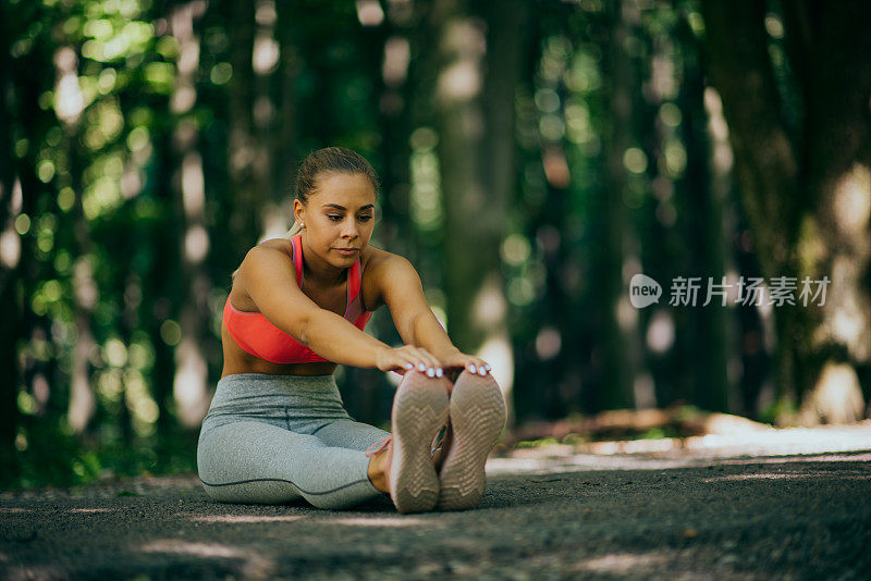 年轻女性跑步者在跑步前热身