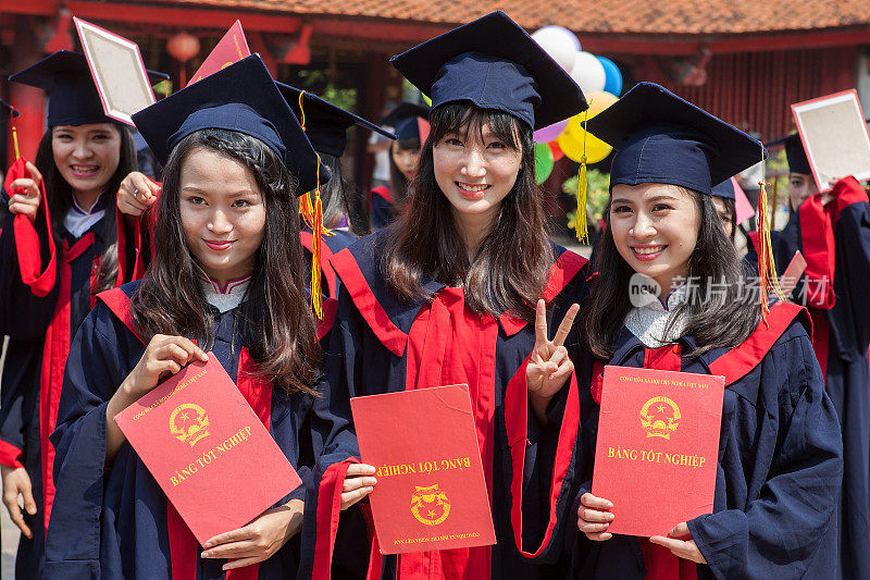 三名快乐的年轻女学生在越南河内的文庙庆祝毕业