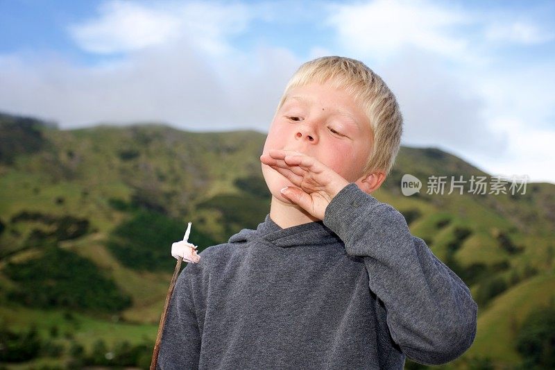 男孩在吃煮好的棉花糖