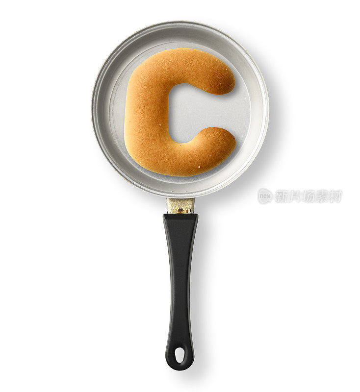 在一个旧的玩具煎锅上，在白色的背景上孤立的字母饼干C