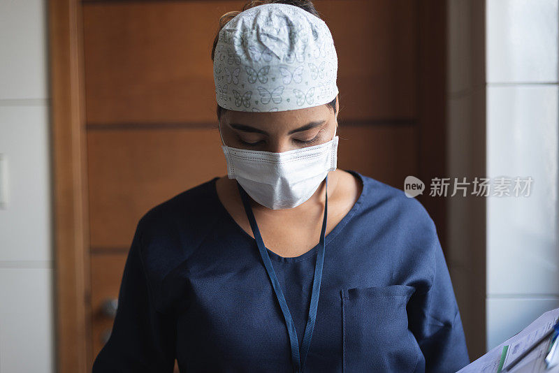 女医生或护士的肖像在医疗手术服戴着保护性面罩