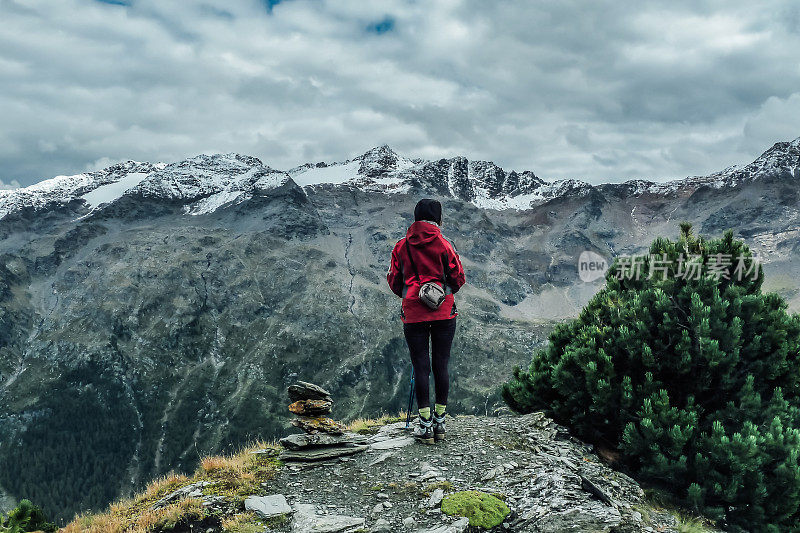 一个女人站在山的边缘看着风景