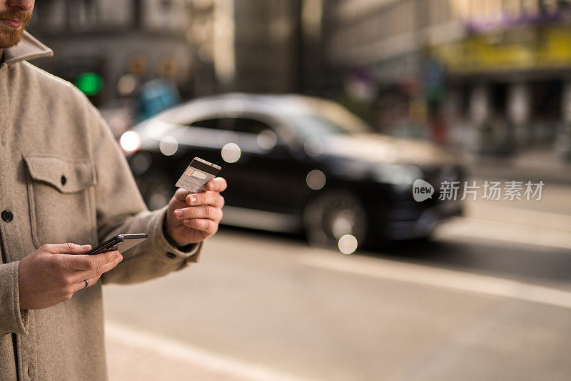 一个年轻人在城市街道上散步时使用网上银行。