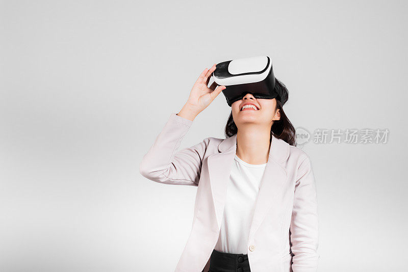 微笑的女子自信兴奋地戴上VR头戴设备进行虚拟现实体验