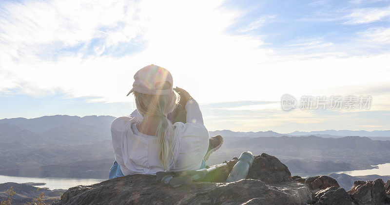 女徒步旅行者在阳光明媚的山脊上休息