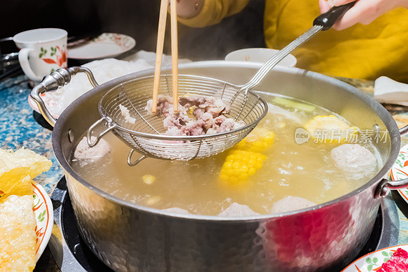 中国福建潮汕牛肉火锅，一块牛肉在火锅里煮熟，捞出来后就可以吃了