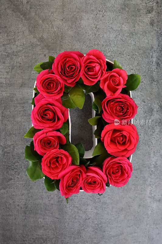 形象的O字母形状，白色花瓶的红玫瑰，灰色的背景，情人节和浪漫的概念，提升的观点