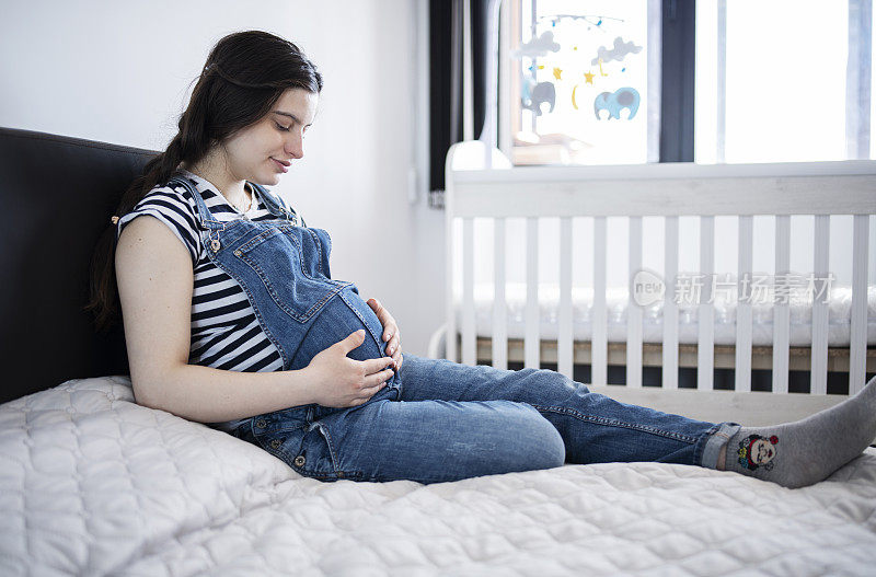 孕妇摸着她的肚子。